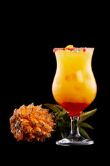 Closeup glass of mai tai cocktail decorated with pineapple isolated at black background.