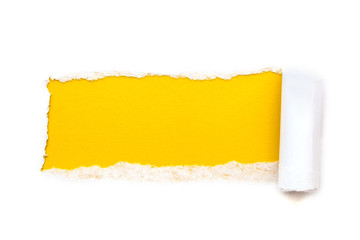 A hole in white paper with torn edges isolated on a white background with a bright yellow color...