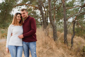 Fototapeta premium Beautiful young couple walking in autumn park.