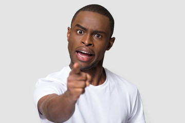 Crazy angry African American man pointing finger at camera