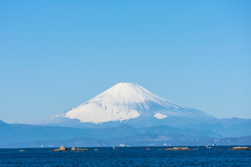 雪をかぶった富士山を相模湾岸に望む