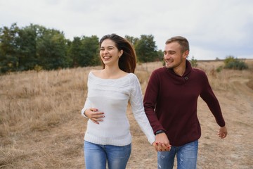Beautiful young couple walking in autumn park.