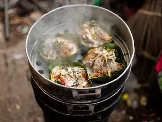 Deurstickers Thai food wrapped in banana leaves on a charcoal stove © jerd nakata