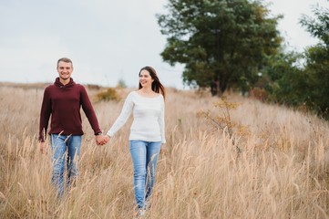 low contrast image of a happy romantic young couple spending time outdoor in the autumn park