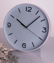 White clock and coins on corner shiny background