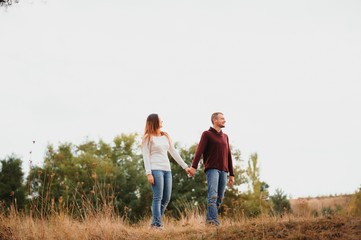 low contrast image of a happy romantic young couple spending time outdoor in the autumn park
