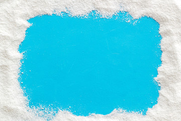 Washing powder scattered on blue background top view frame copy space