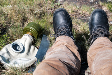 a halt after a hike in the radiation-contaminated area of a gas mask and a machete next to the legs