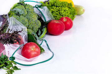 Seasonal fruits and vegetables on white. Raw organic fresh food from market. Zero waste shopping. Reusable grocery bags