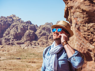 Fototapeta premium Handsome man, exploring the sights of the ancient, fabulous city of Petra in Jordan. Colorful photos. Concept of leisure, vacation and travel