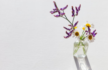 bouquet of flowers in glass vase on white background
