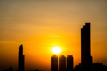 Background of Beautiful sunset over modern office building tower in business district downtown center of Bangkok.Cityscape urban of Bangkok city at night in warm light colour tone.