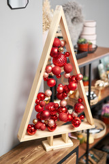 Alternative wooden christmas tree. A handmade Christmas tree and red christmas balls.