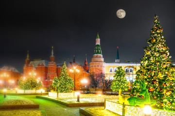 Fototapeta na wymiar christmas moscow kremlin russia landmark winter decoration for new year celebration at night against moon on black sky background. Street wide view of red square ancient architecture. Creative blur