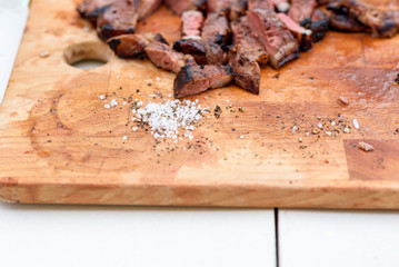 Goose breast with spiced and coarse salt for Christmas on wooden board.
