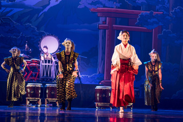 Traditional Japanese performance. Group of actresses in traditional white and red kimono and fox masks dance on the stage.