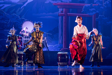 Traditional Japanese performance. Group of actresses in traditional white and red kimono and fox masks dance on the stage.