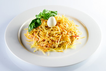 hearty salad with quail egg and basil leaf on a white background