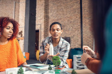Student standing near board and presenting his ideas to friends