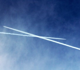 two trails of airplanes crossing in the sky