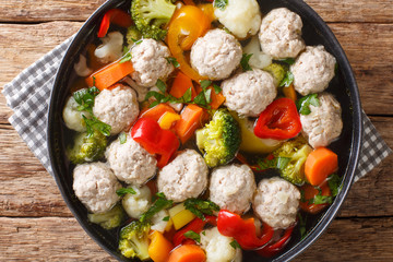 Diet meatballs with broccoli, pepper, cauliflower, potatoes and carrots close-up in a plate. Horizontal top view