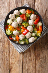 Tasty meatballs with broccoli, cauliflower, potatoes and carrots close-up in a plate. Vertical top view