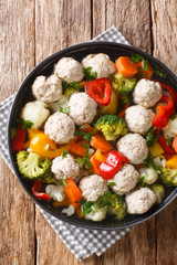 Healthy soup with chicken meatballs and vegetables close-up in a plate. Vertical top view