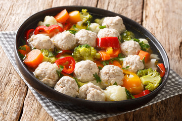 Serving soup with meatballs and vegetables close-up in a plate. horizontal