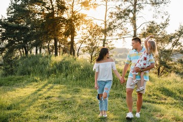 happy family concept - father, mother and child daughter having fun and playing in nature.