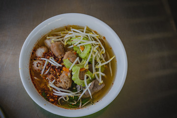 Chicken noodles soup in bowl at noodle shop street .