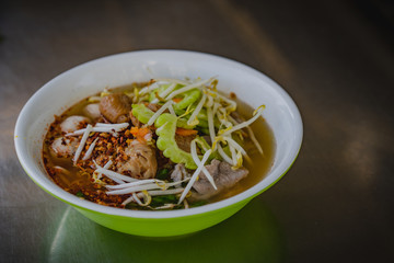 Chicken noodles soup in bowl at noodle shop street .