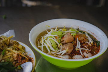 Chicken noodles soup in bowl at noodle shop street .