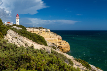Fototapeta na wymiar Farol de Alfanzina, a lighthouse near Carvoeiro at the southern coast of the Algarve, Portugal.