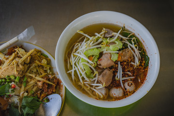 Chicken noodles soup in bowl at noodle shop street .
