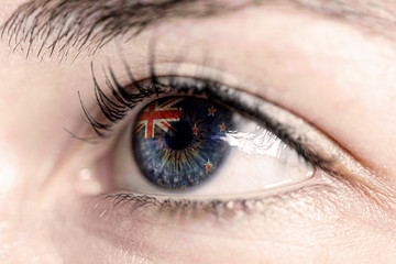 Fototapeta na wymiar Flag of new zealand, reflects in woman green eye - close-up view - election, sport, hope, young, generation 