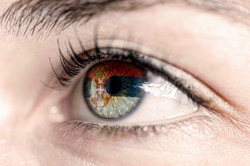 Fototapeta na wymiar Flag of serbia reflects in woman green eye - close-up view - election, sport, hope, young, generation 