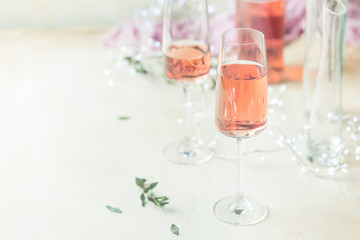 Two glasses and bottle of rose wine on light background.