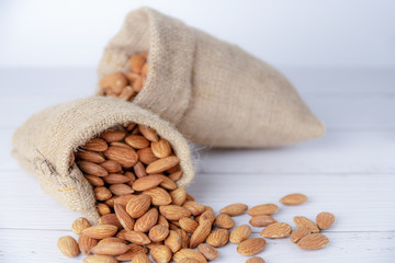 Almond in cloth bag on blurred white table