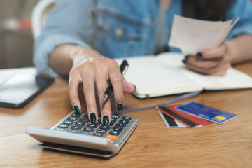 Woman doing accounting home finance expenses and calculate credit card monthly debt to bills payment.