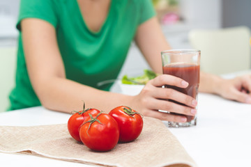 Obraz na płótnie Canvas Low calories drink for wellness. woman making homemade drink by extracting fresh tomato juice.