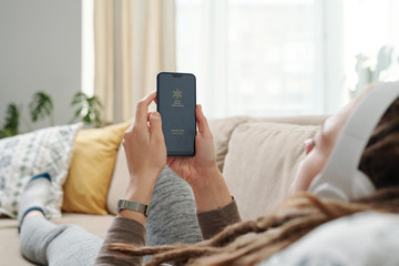 Hands of young restful woman holding smartphone in front of herself