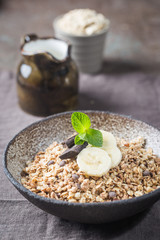 Healthy breakfast bowl. Granola with chocolate and banana on white wooden table. The concept of healthy nutrition and diet.