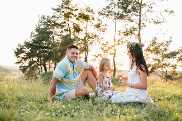 Fototapeta premium happy family concept - father, mother and child daughter having fun and playing in nature.