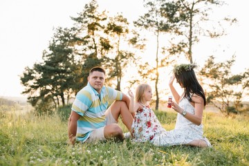 happy family concept - father, mother and child daughter having fun and playing in nature.