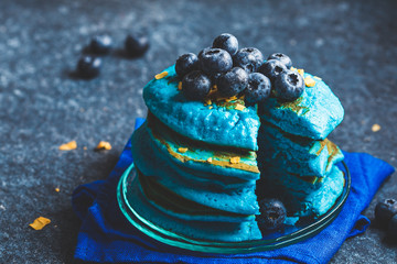 Blueberry blueberry pancakes with coconut chips on dark background.