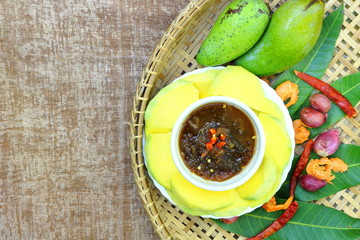 Raw mango slice with sweet dried shrimp sauce, have red chili, onion, fish sauce, shrimp paste and sugar in there. It's special food in Thailand in summer season.