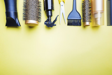 Various hair dresser and cut tools on yellow background with copy space