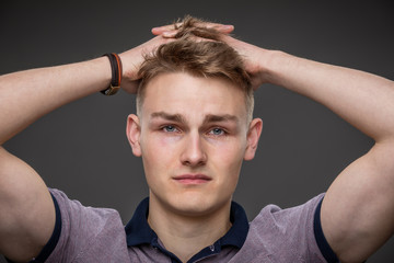 A handsome boy hold his head while crying