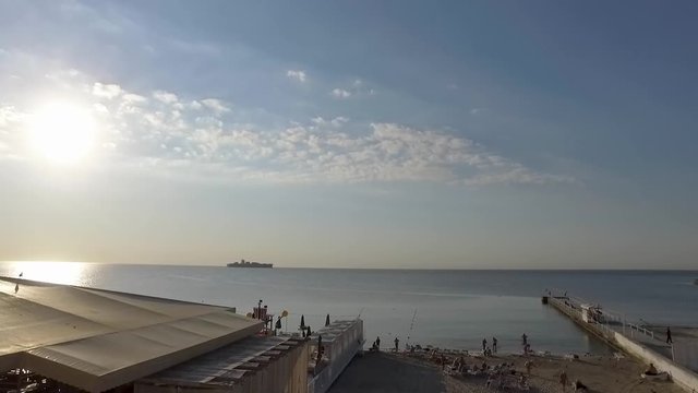 Black Sea resort early morning container ship on the horizon in Odessa Ukraine slow pan static two times speed