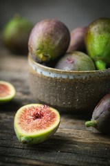 Fresh ripe figs in a bowl closeup on dark background, rustic style